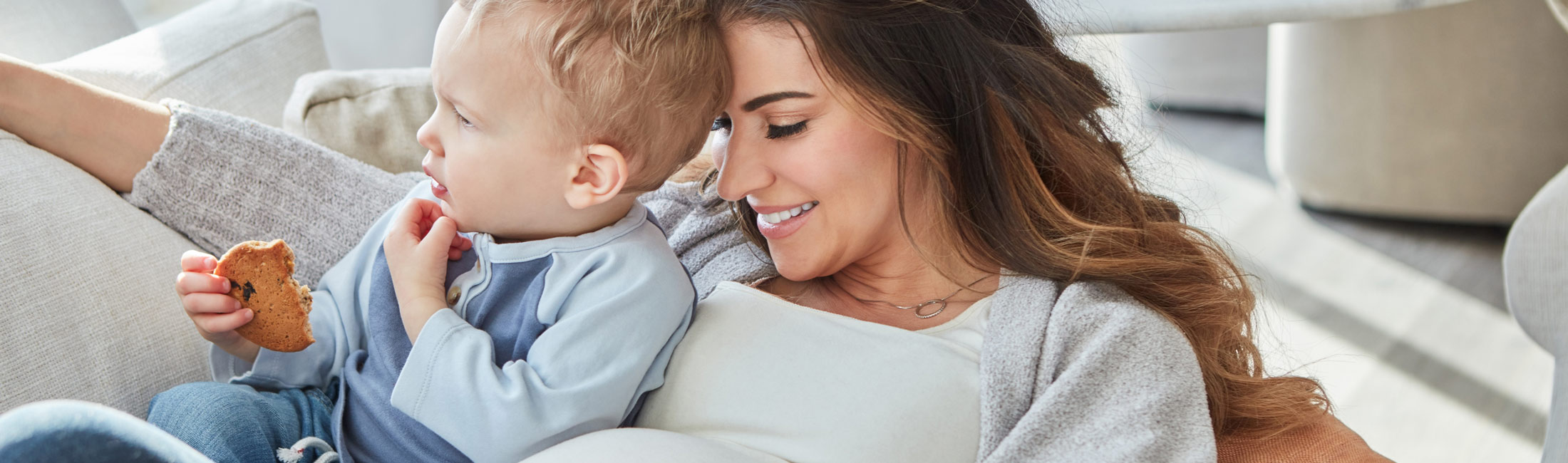 Pregnant mother with young child on couch