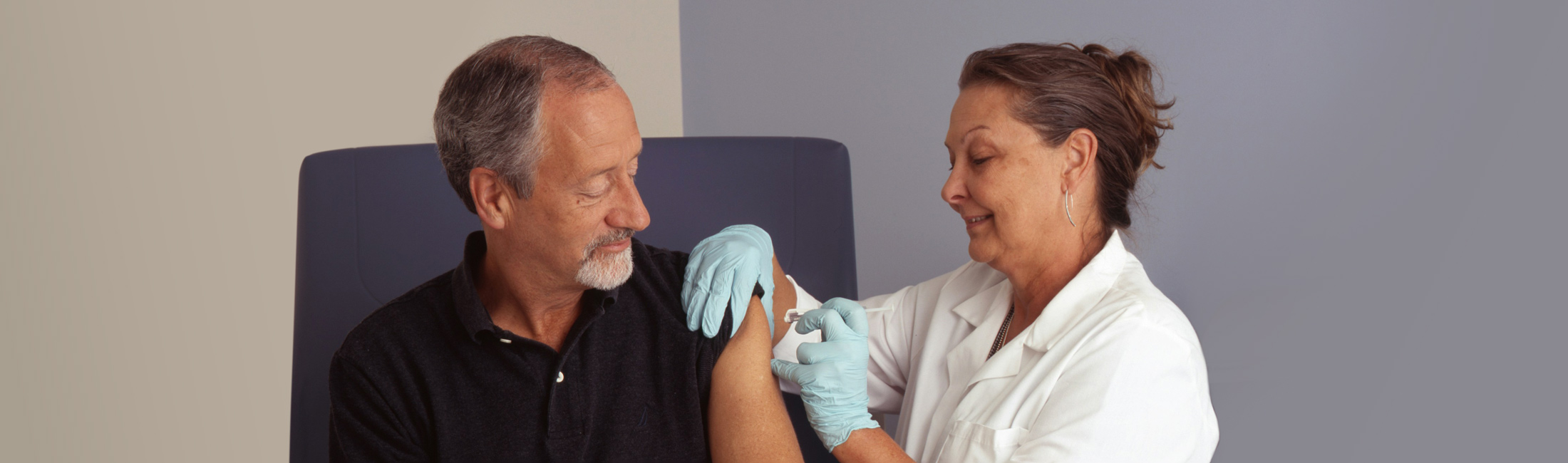 man getting shot in arm from nurse