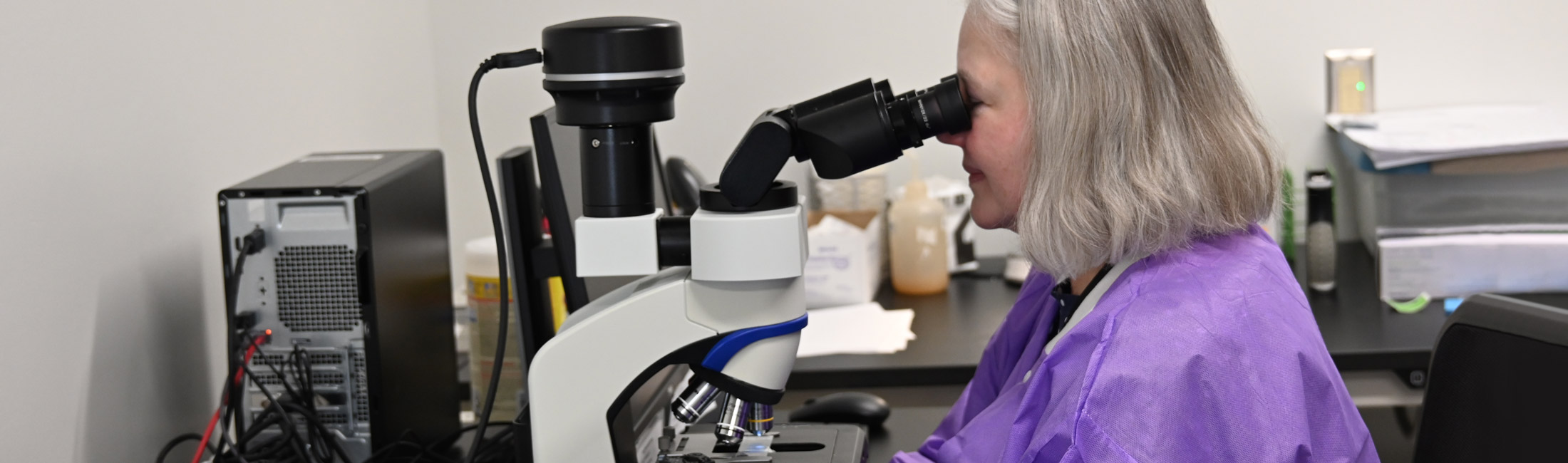 woman examining sample with microscope