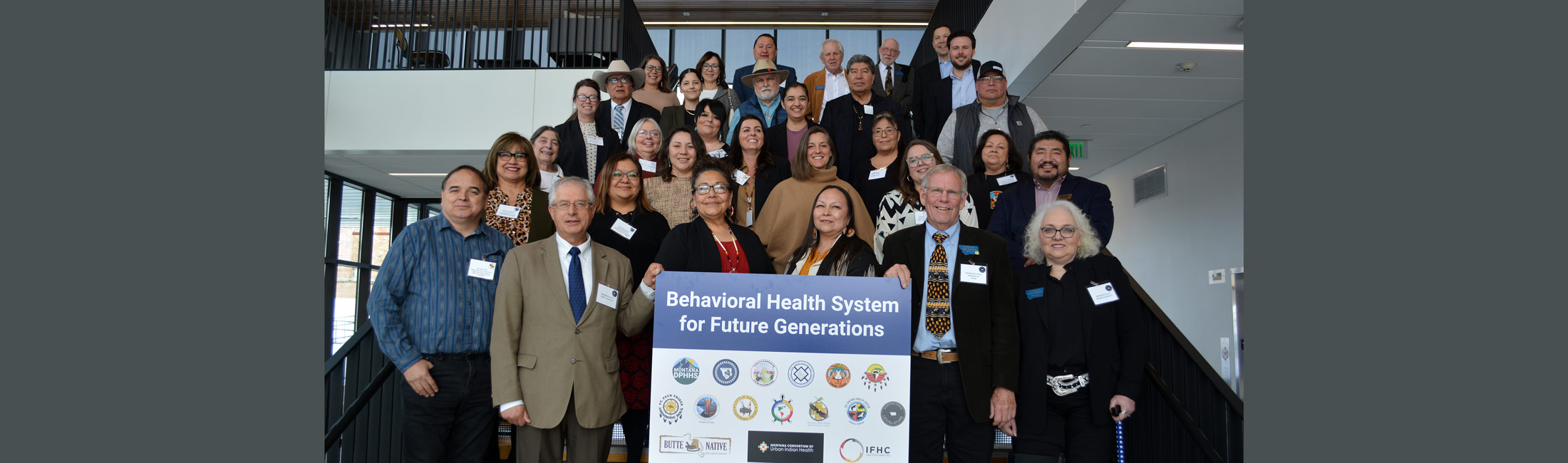 people standing on staircase with poster for Behavioral Health System for Future Generations