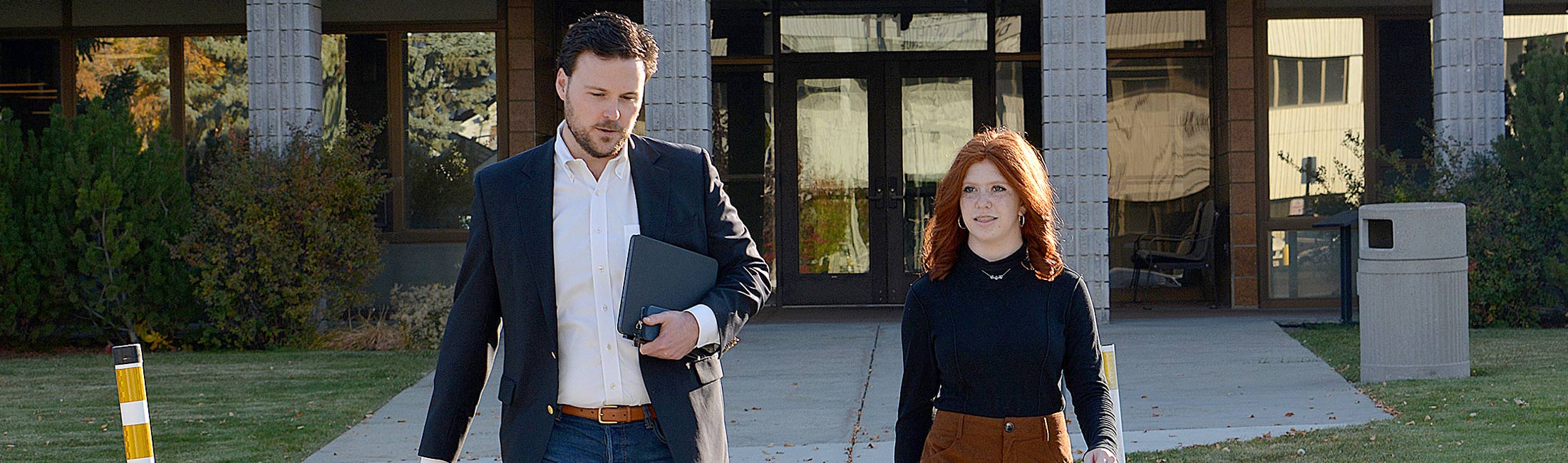 Charlie Brereton crossing the street with woman in front of the Sanders building