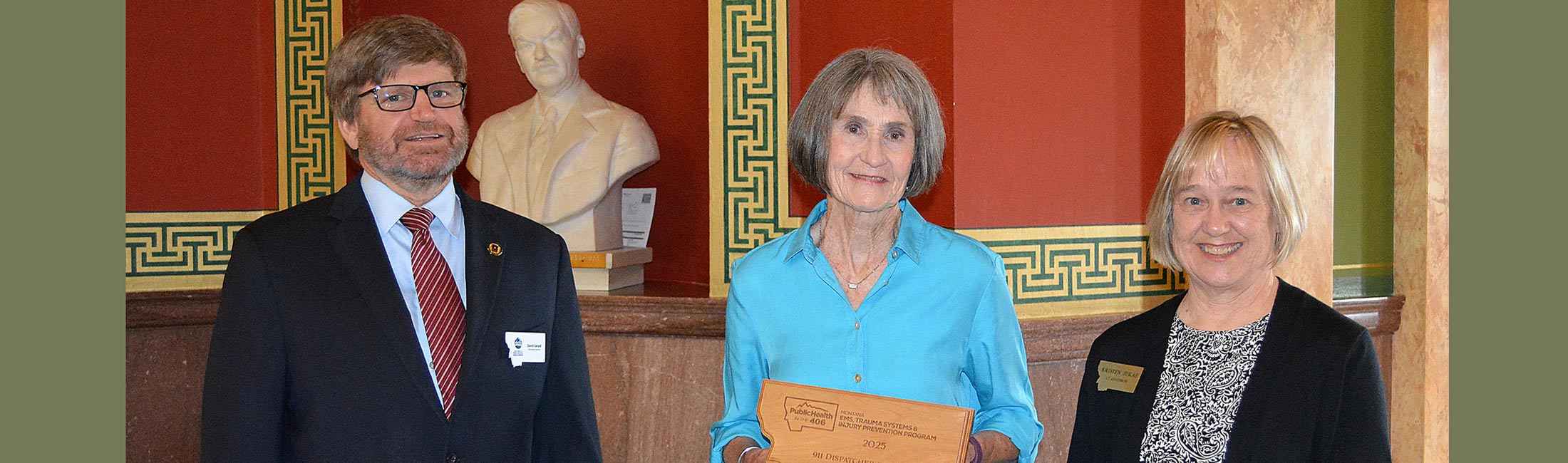 911 Dispatcher of the Year Award recipient Dayle Perrin, middle, of East Helena, along with DPHHS Executive Director Dave Gerard, left, and Lt. Gov. Kristen Juras.  