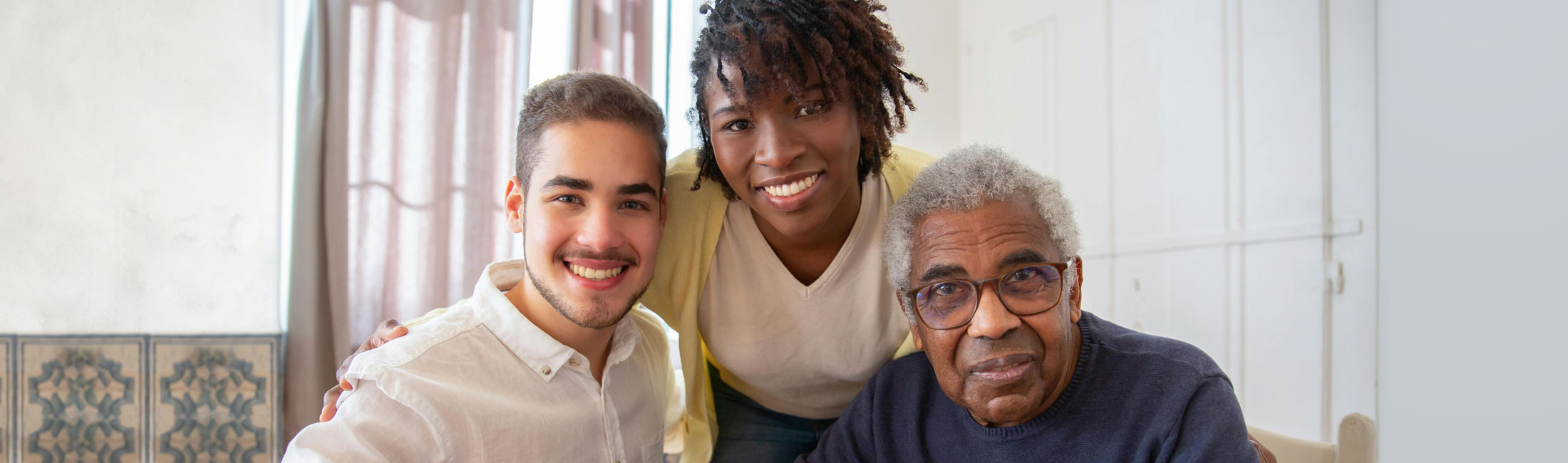 a man with a woman and an elderly man sitting at table