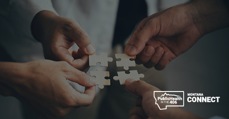 Four hands holding a puzzle piece