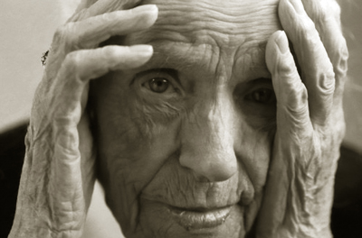 Closeup photo of an elderly man resting his head on his hands