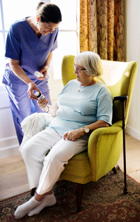 Nurse giving medication to an elderly woman